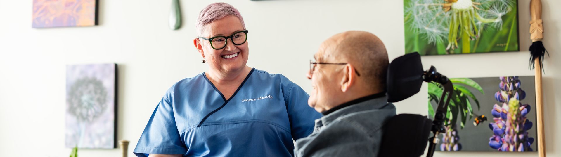 A nurse is talking to a man in a wheelchair.