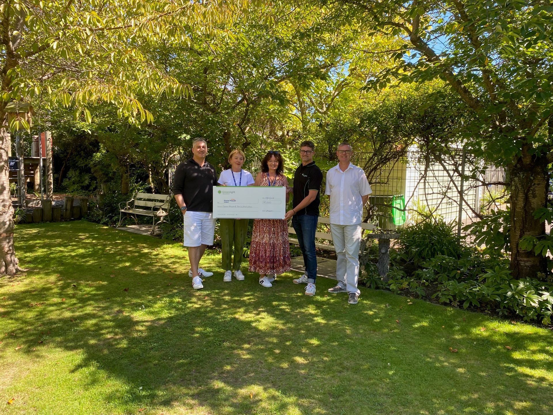 Nurse Maude's staff golf team recieves a large cheque for $7,500.