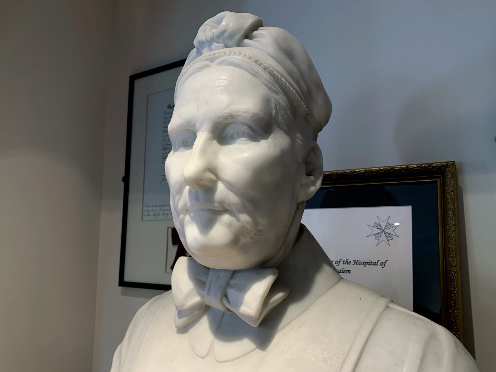 A statue of a man wearing a hat and bow tie - Nurse Maude