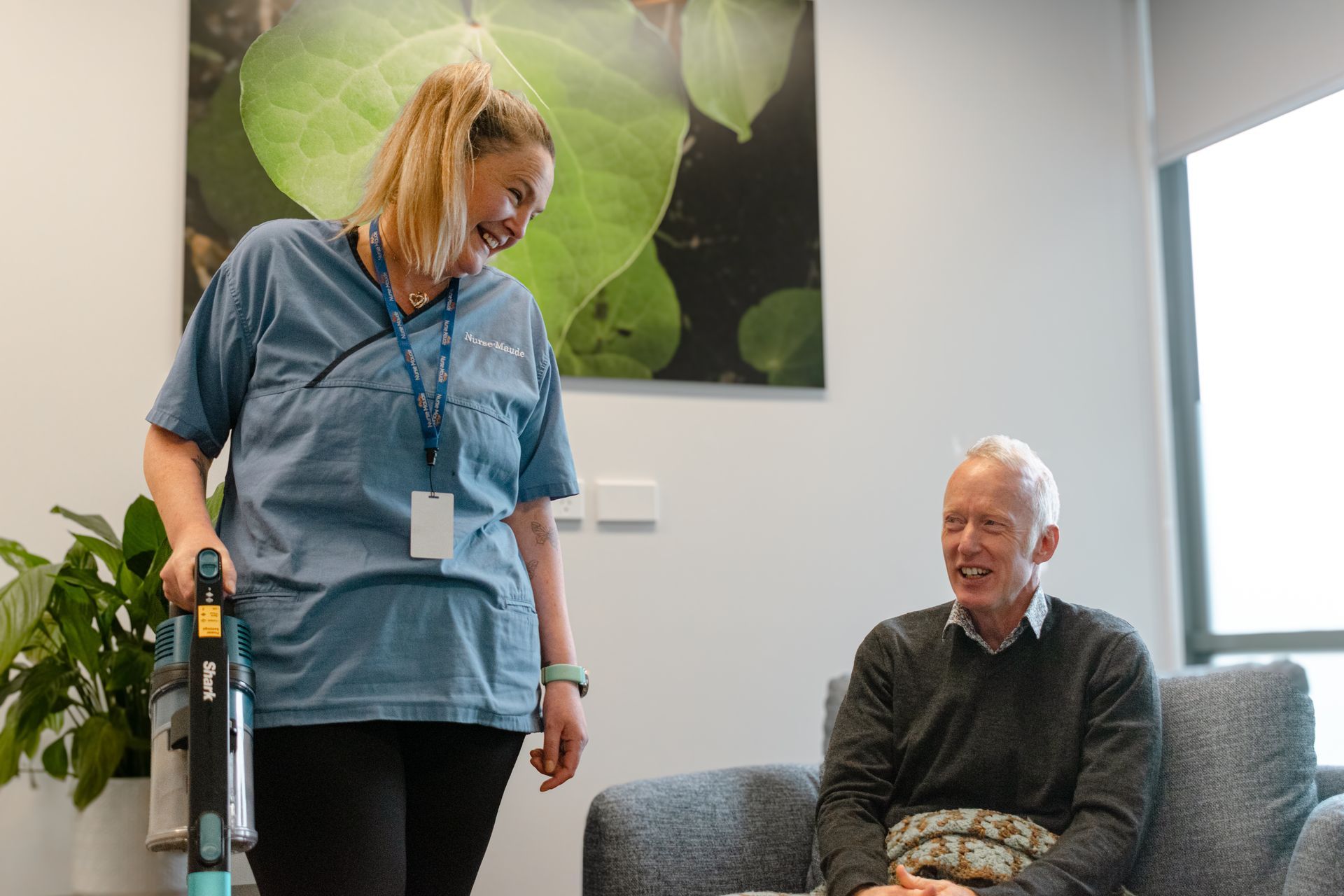 A nurse is giving an elderly man a pill in his mouth.