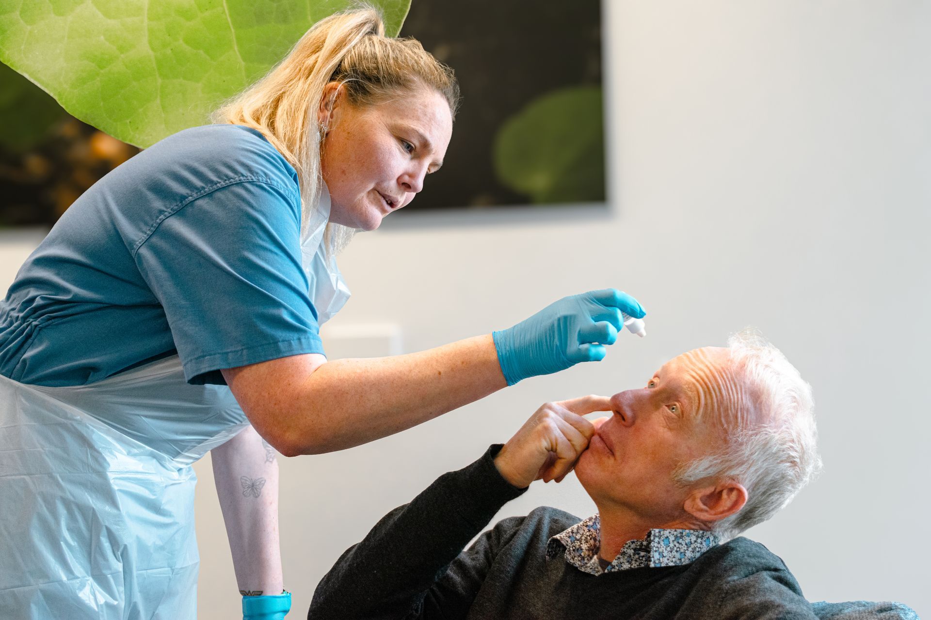 A nurse is talking to a man in a wheelchair