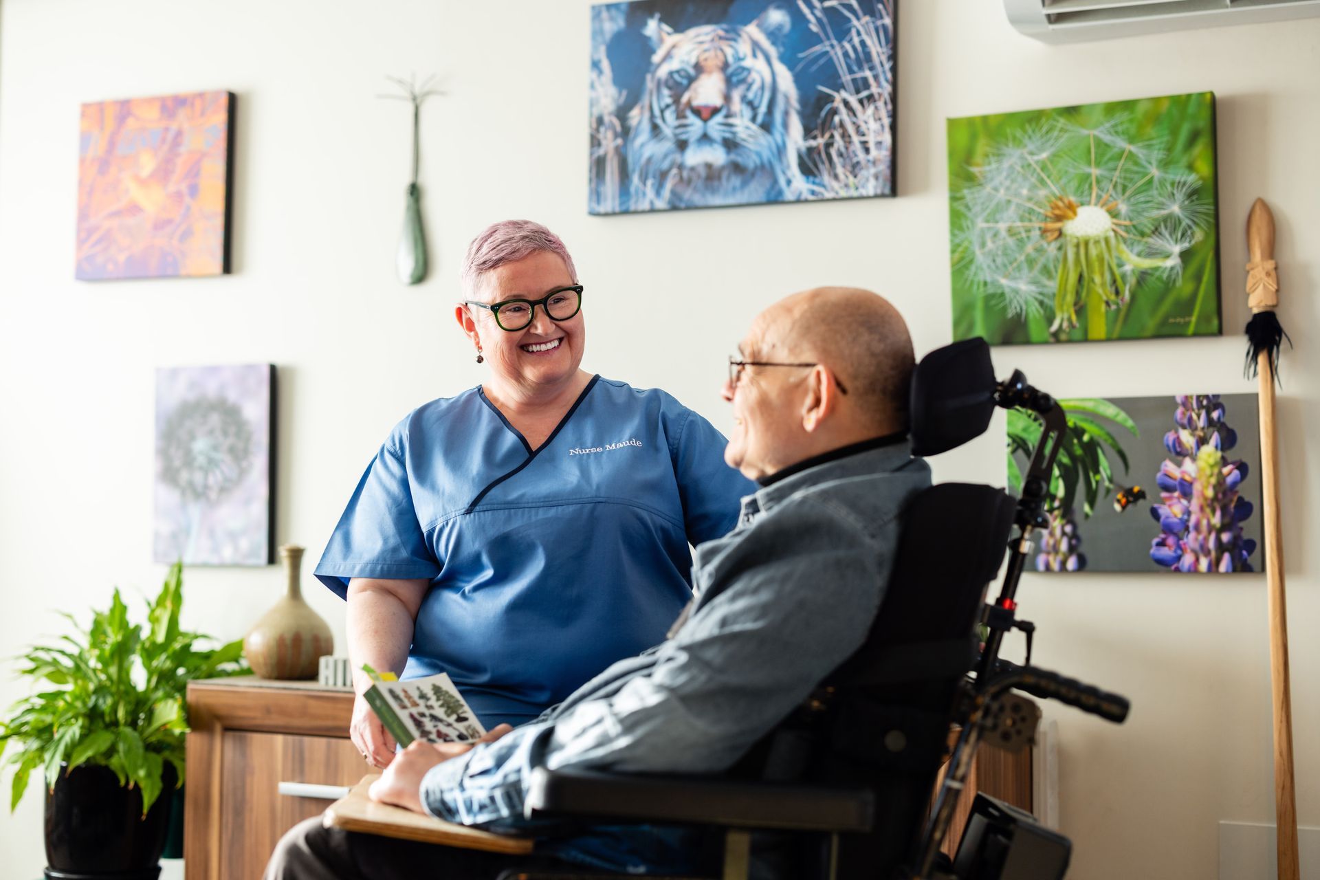 A nurse is talking to a man in a wheelchair