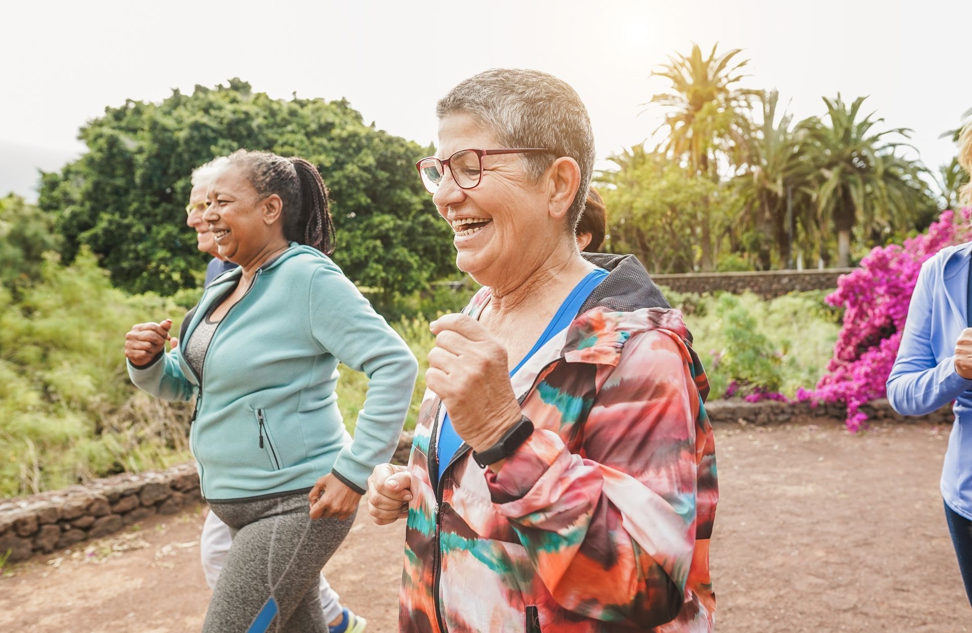 A group of older women are jogging together in a park.