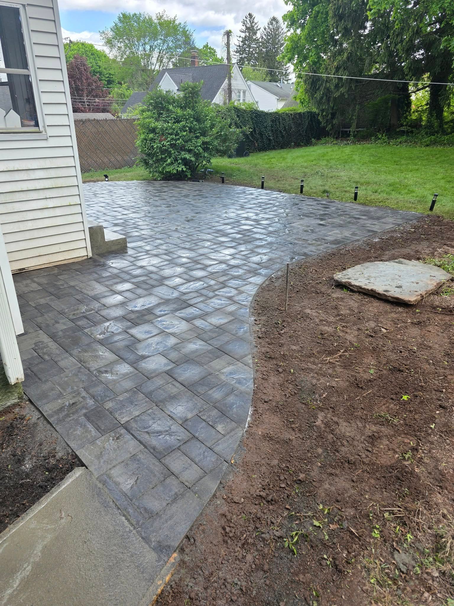 A patio is being built in the backyard of a house.