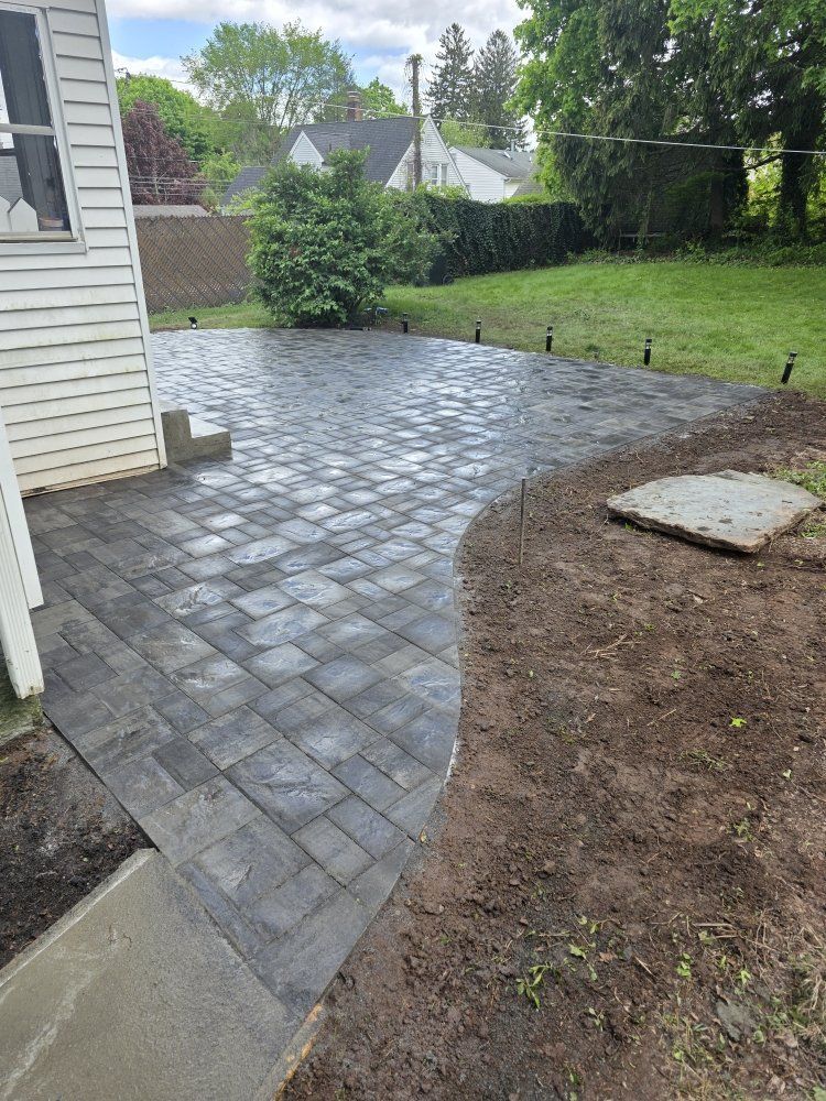 A patio is being built in the backyard of a house.