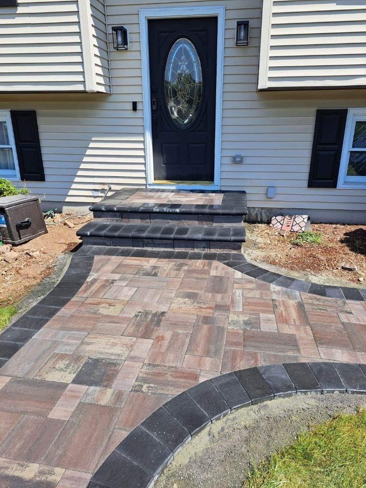 A brick walkway leading to the front door of a house.