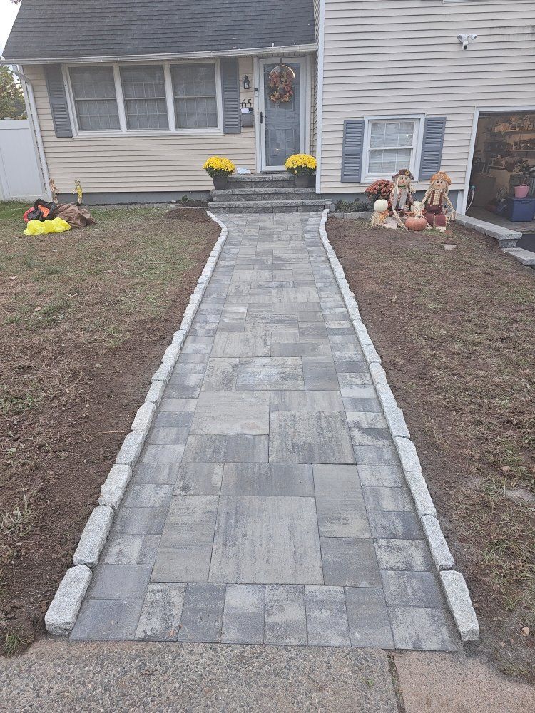 A brick walkway leading to the front door of a house.