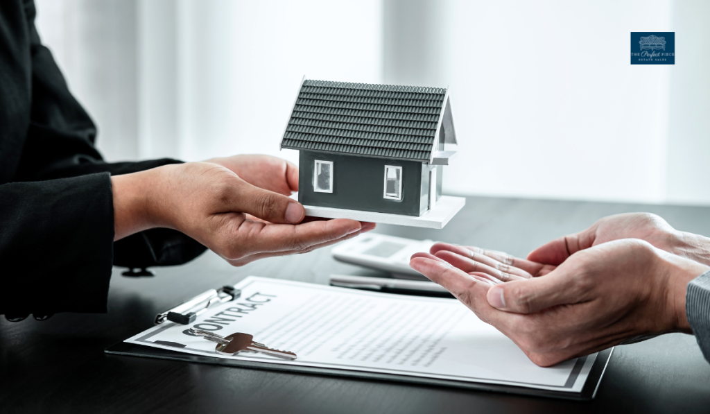 A person is holding a model house and keys in their hands.