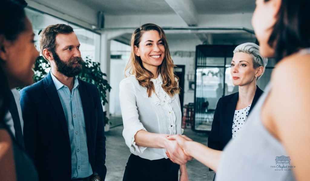 A group of business people are shaking hands in an office.