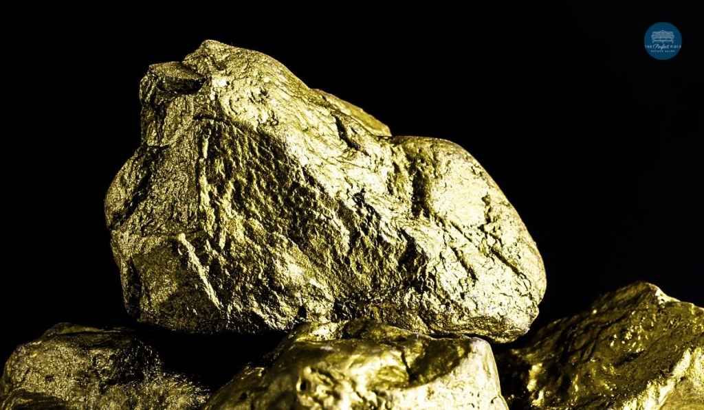 A pile of gold nuggets on a black background.