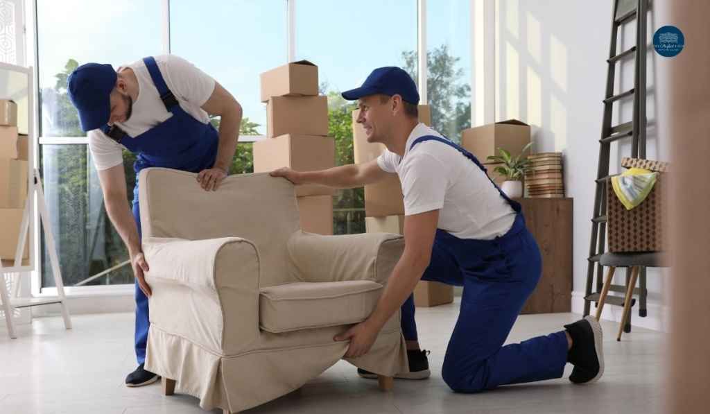 Two men are moving a chair in a living room.