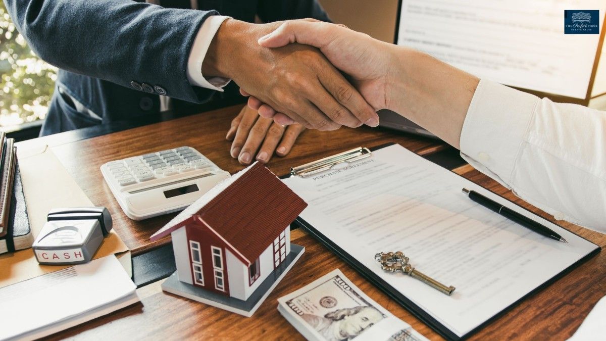 A man and a woman are shaking hands over a table with a model house and money.