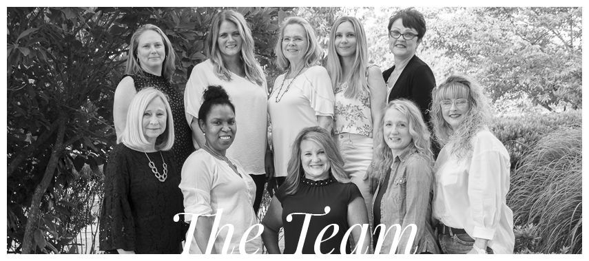 A group of women are posing for a picture together in a black and white photo.