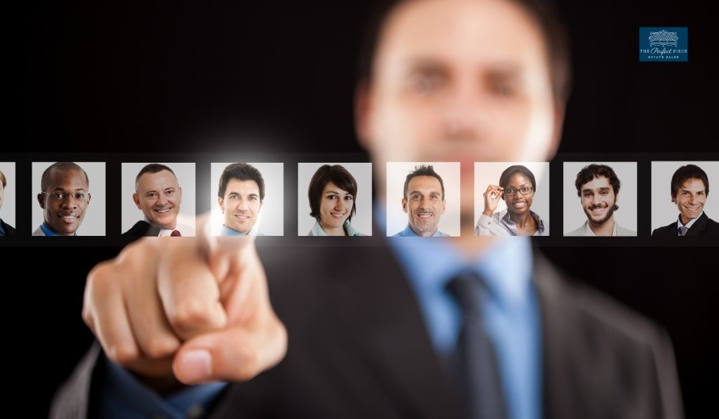 A man in a suit is pointing at a row of people 's faces