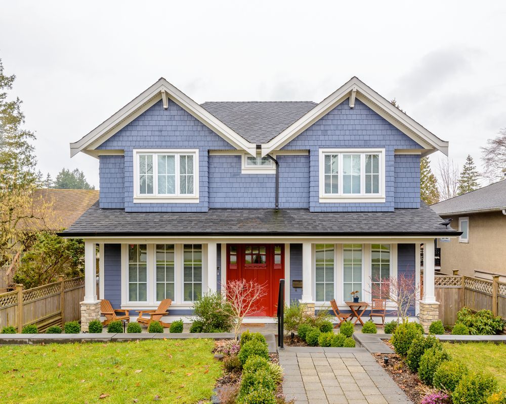 A wooden fence is in front of a house.