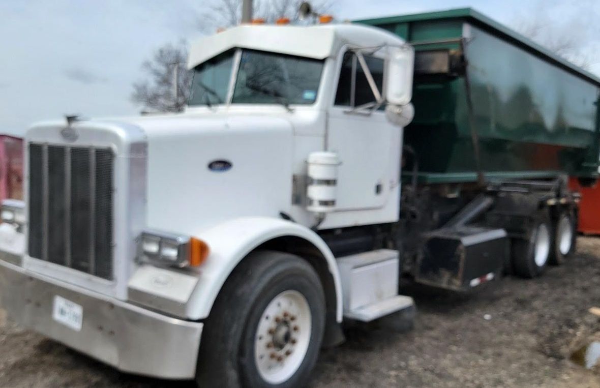 A Mars Waste truck with a dumpster attached to it
