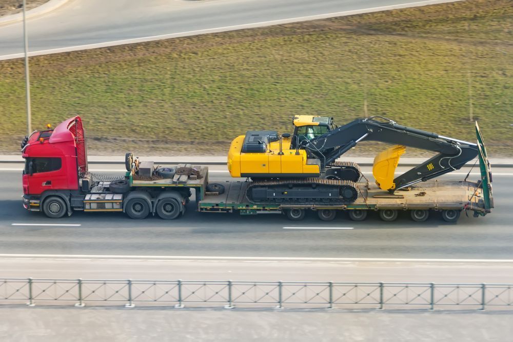 Heavy yellow excavator on transportation truck - Transport Company in Emerald