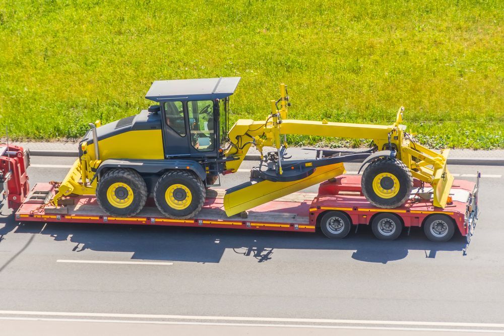 Grader tractor on transportation trailer truck - Transport Company in Emerald