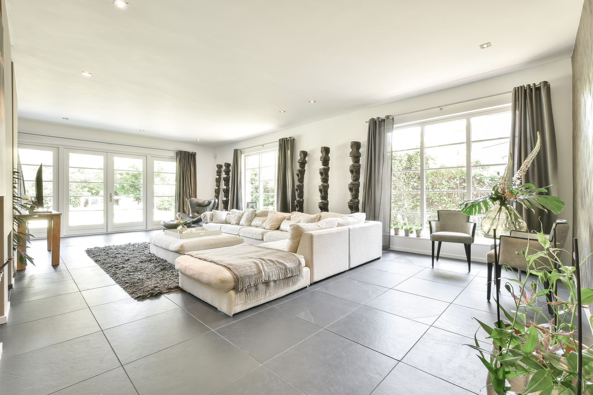 A person in black clothing mops a hardwood floor.
