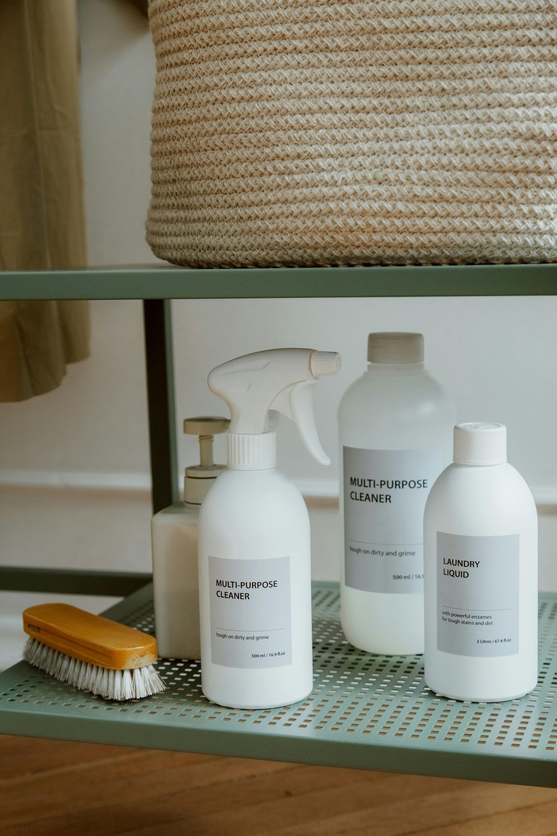 A hand holds a white spray bottle.