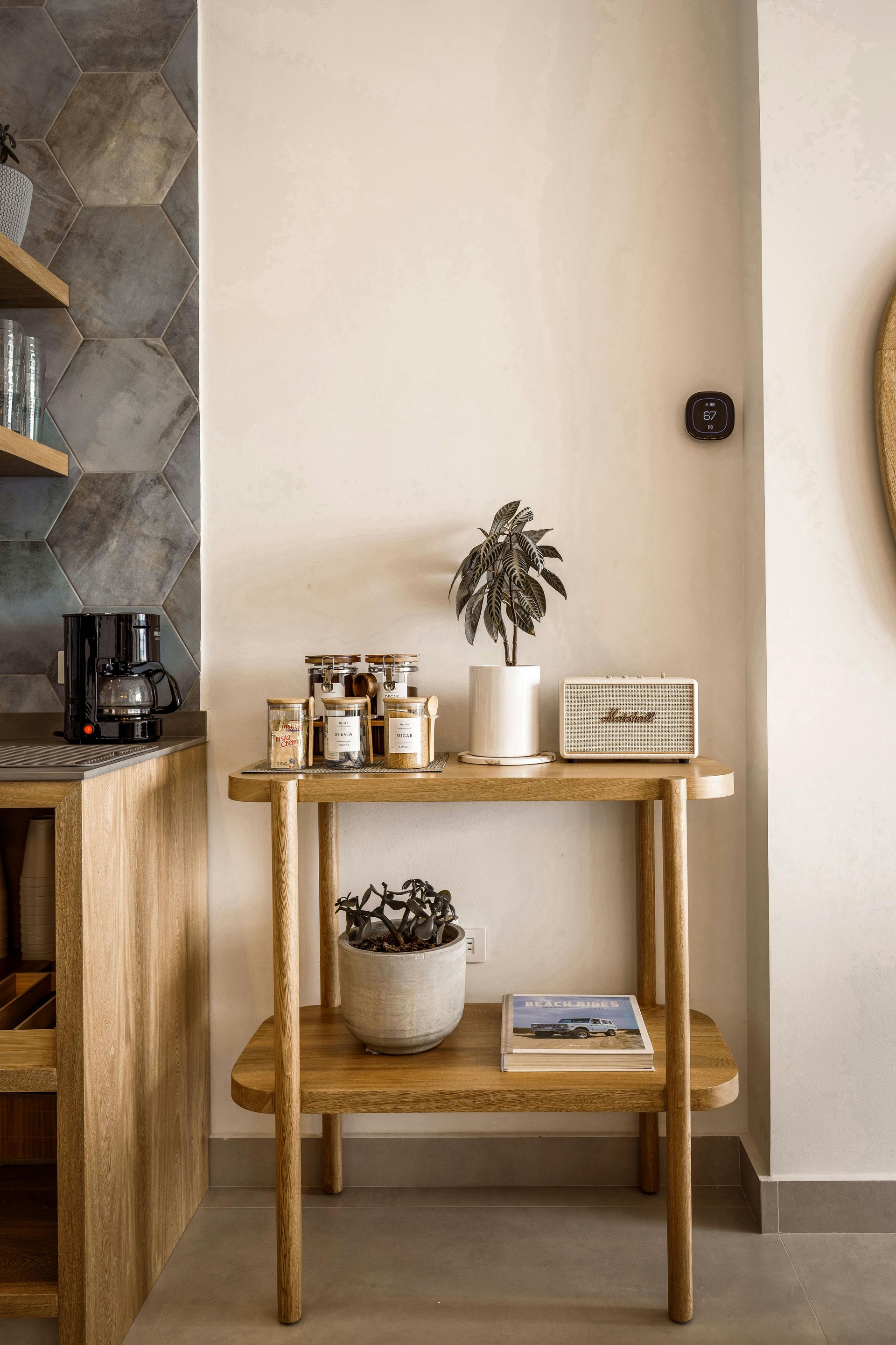 A wooden two-tiered side table against a white wall.