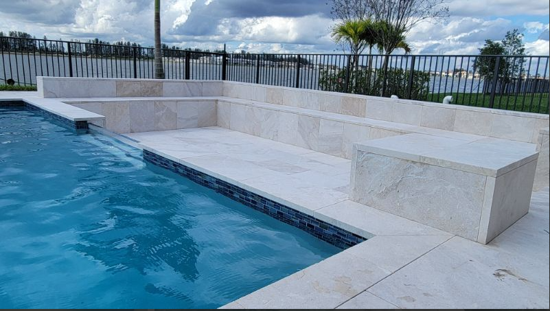 A swimming pool with steps leading up to it and a fence surrounding it.