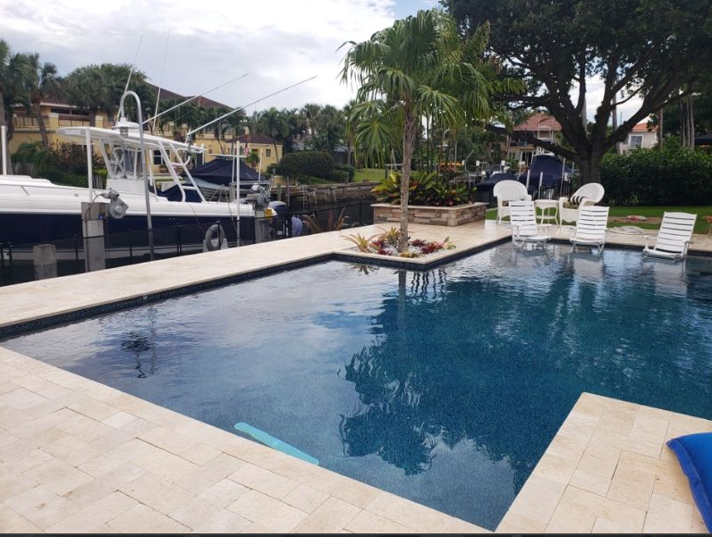 A large swimming pool with a boat in the background