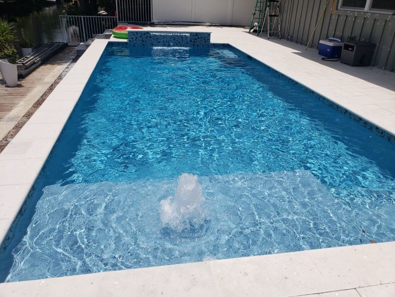 A large swimming pool with a waterfall in the middle of it.