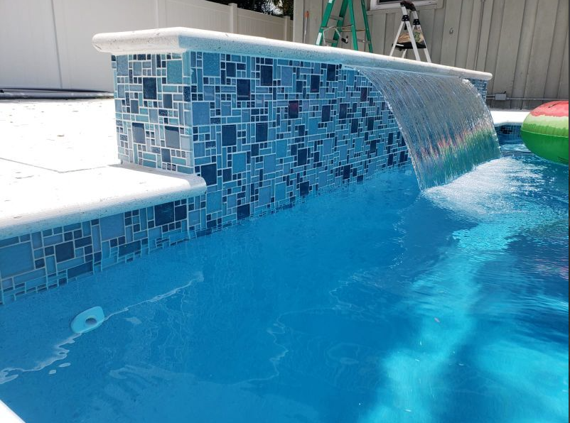 There is a waterfall in the middle of the pool.