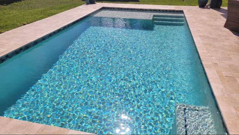 A large swimming pool with stairs in the backyard.