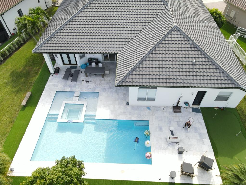 An aerial view of a house with a large swimming pool