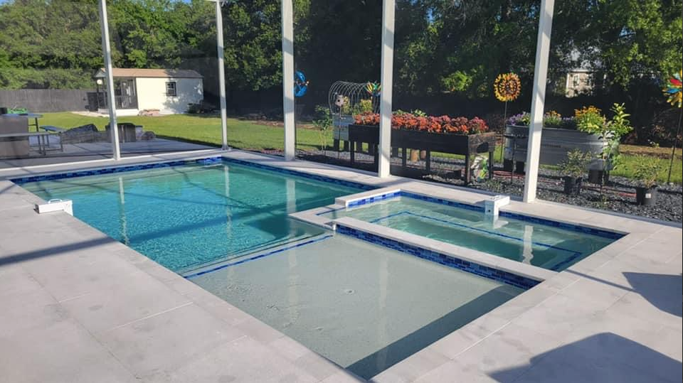 There is a large swimming pool and a hot tub in the backyard.