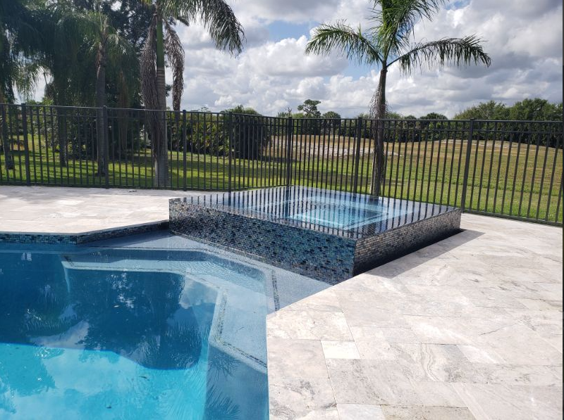 A large swimming pool with a hot tub in the middle of it.