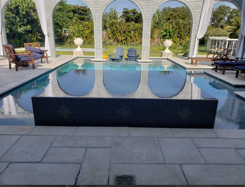 A large swimming pool with arches and chairs around it
