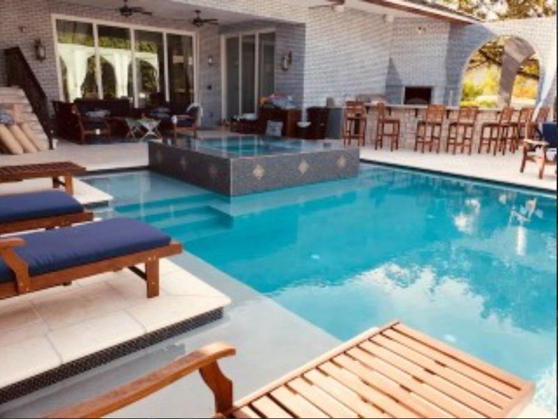 A large swimming pool surrounded by chairs and tables