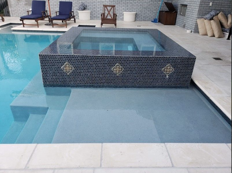 A swimming pool with a hot tub in the middle