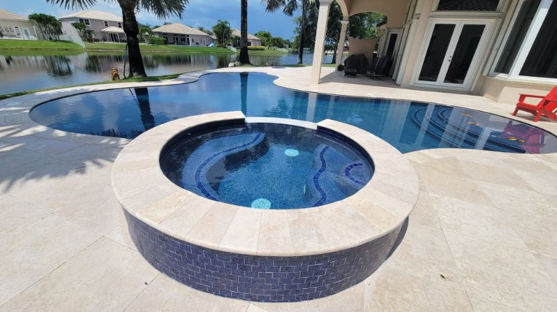 A large swimming pool with a hot tub in the middle of it