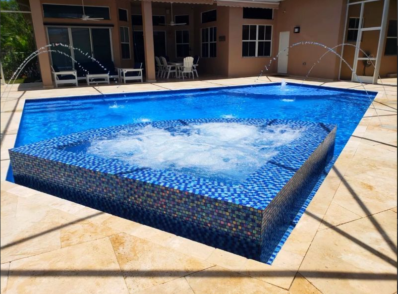 A large swimming pool with a jacuzzi in the middle