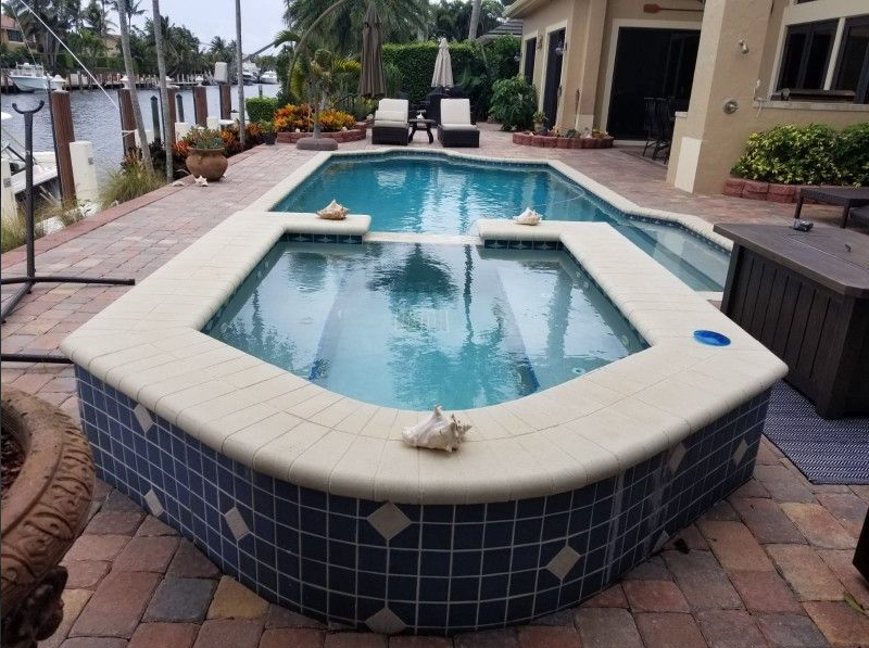 A large swimming pool with a hot tub in the middle