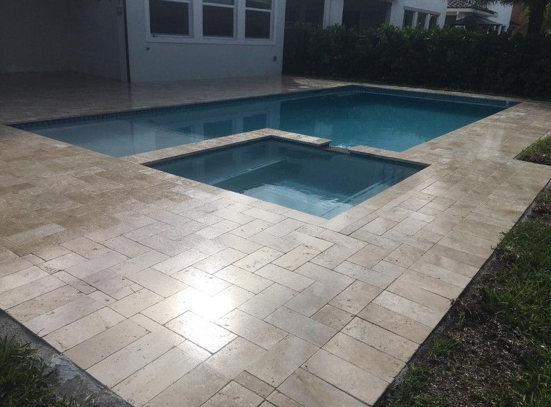 A large swimming pool with a hot tub next to it.