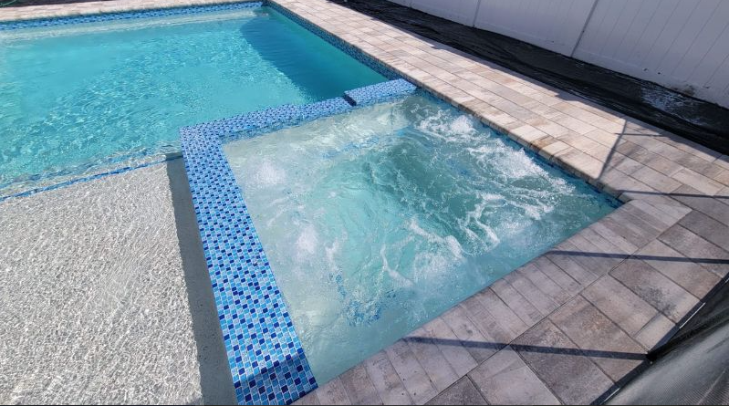 A swimming pool with a hot tub in the middle of it.