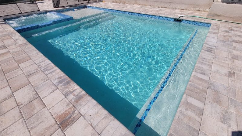 A large swimming pool with a hot tub attached to it.