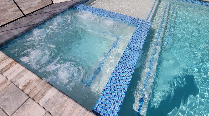 A swimming pool with a jacuzzi in the middle of it.