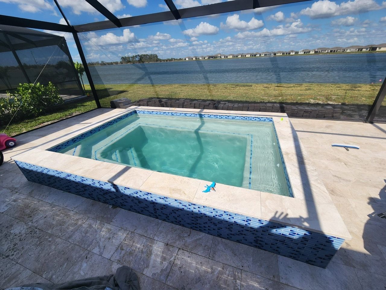 A large swimming pool with a view of a lake.