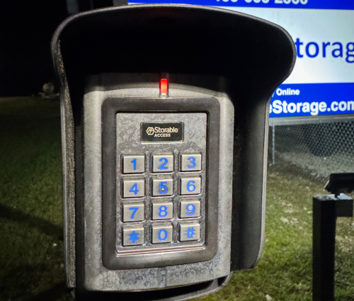 Tenant entering gate code at secure storage facility.