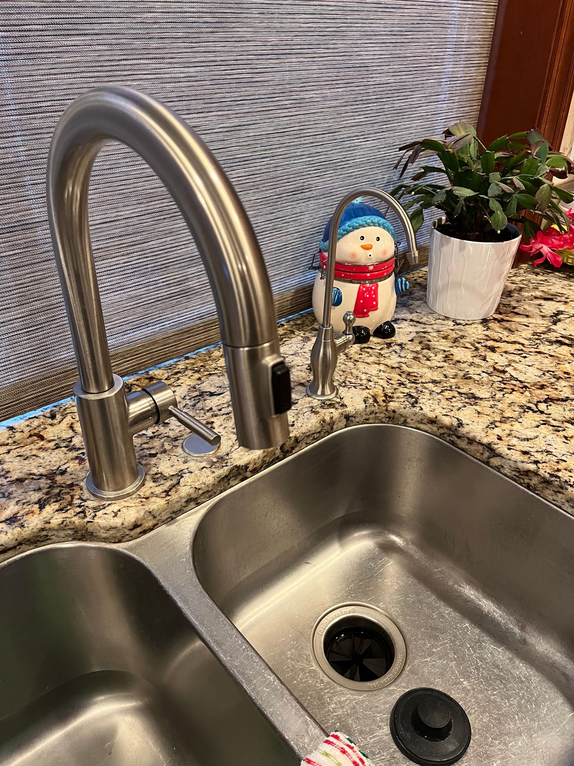 A stainless steel kitchen sink with a snowman on top of it.