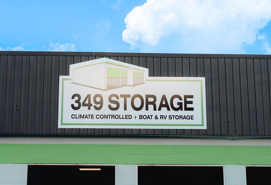 Sign for 349 Storage with illustration of a storage unit, below a blue sky. Says 