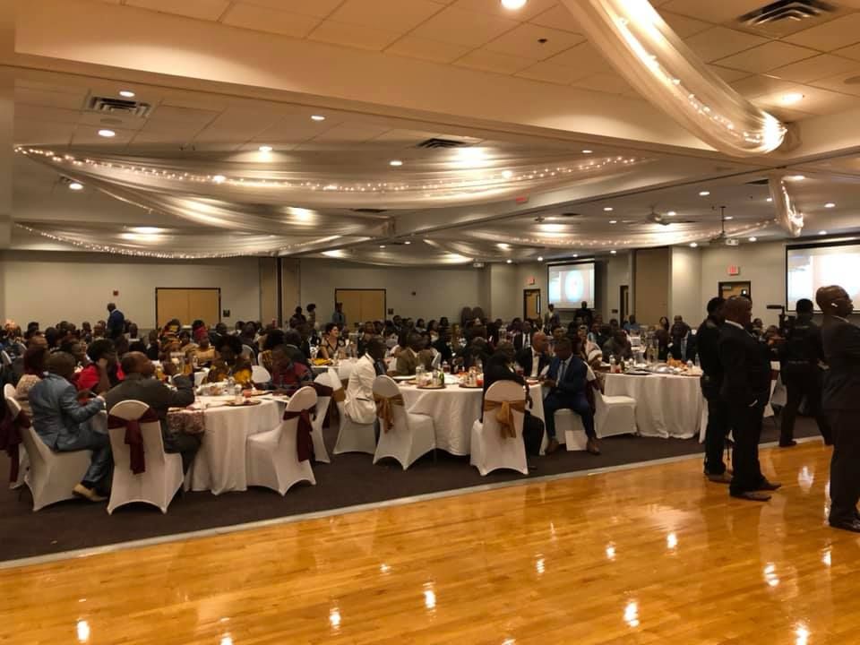 A large room with tables and chairs set up for a wedding reception.