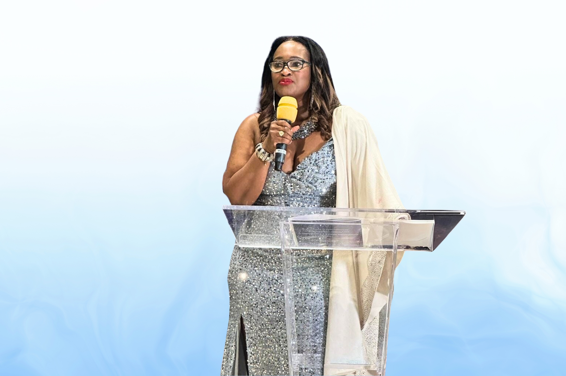 A woman is standing at a podium holding a microphone.