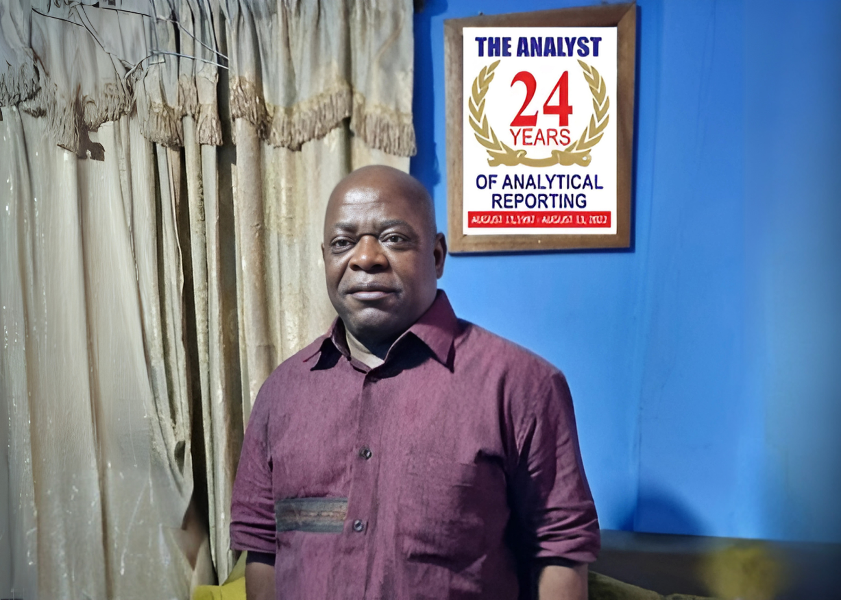 A man is standing in front of a sign that says the analyst 24 years of analytical reporting